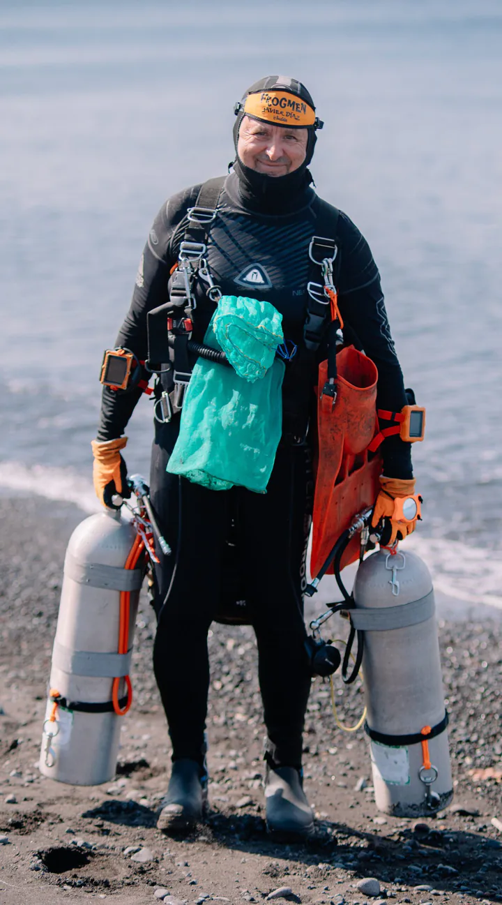 A diver in full kit on the beach before an Ocean Prosperity reef cleanup