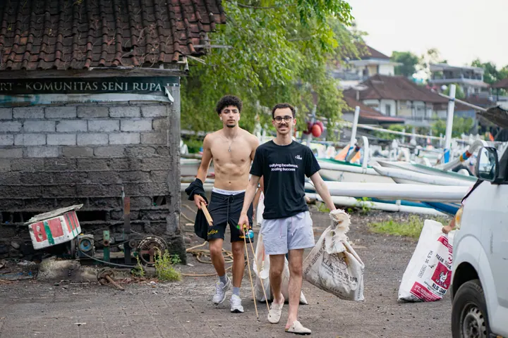 MS Capital volunteers carrying bags of collected waste near the beach in Bali
